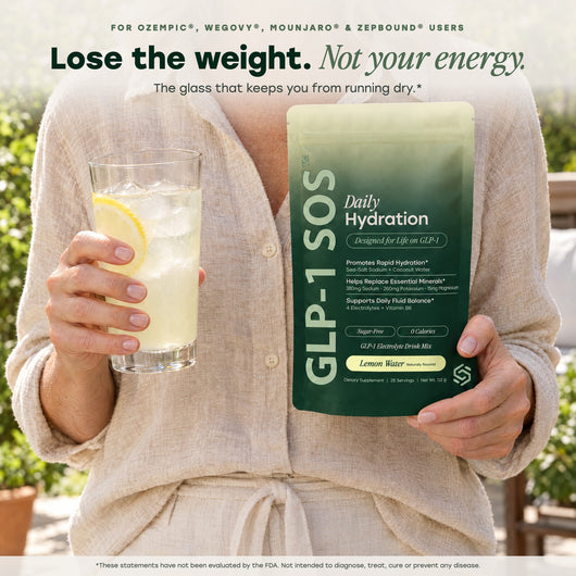 Woman holding Daily Hydration and a glass of lemon water